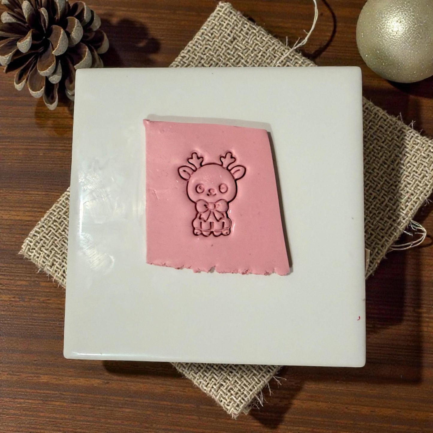 pink reindeer clay impression on white tile