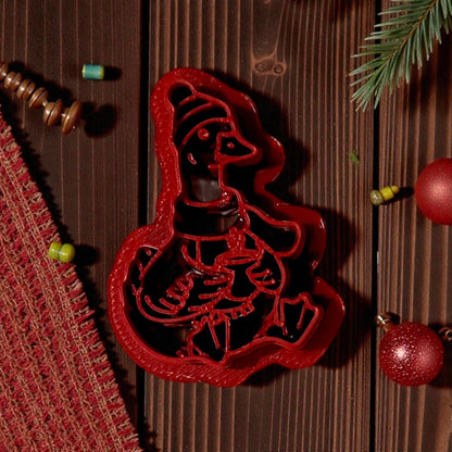 red goose polymer clay cutter on wood with pinecones