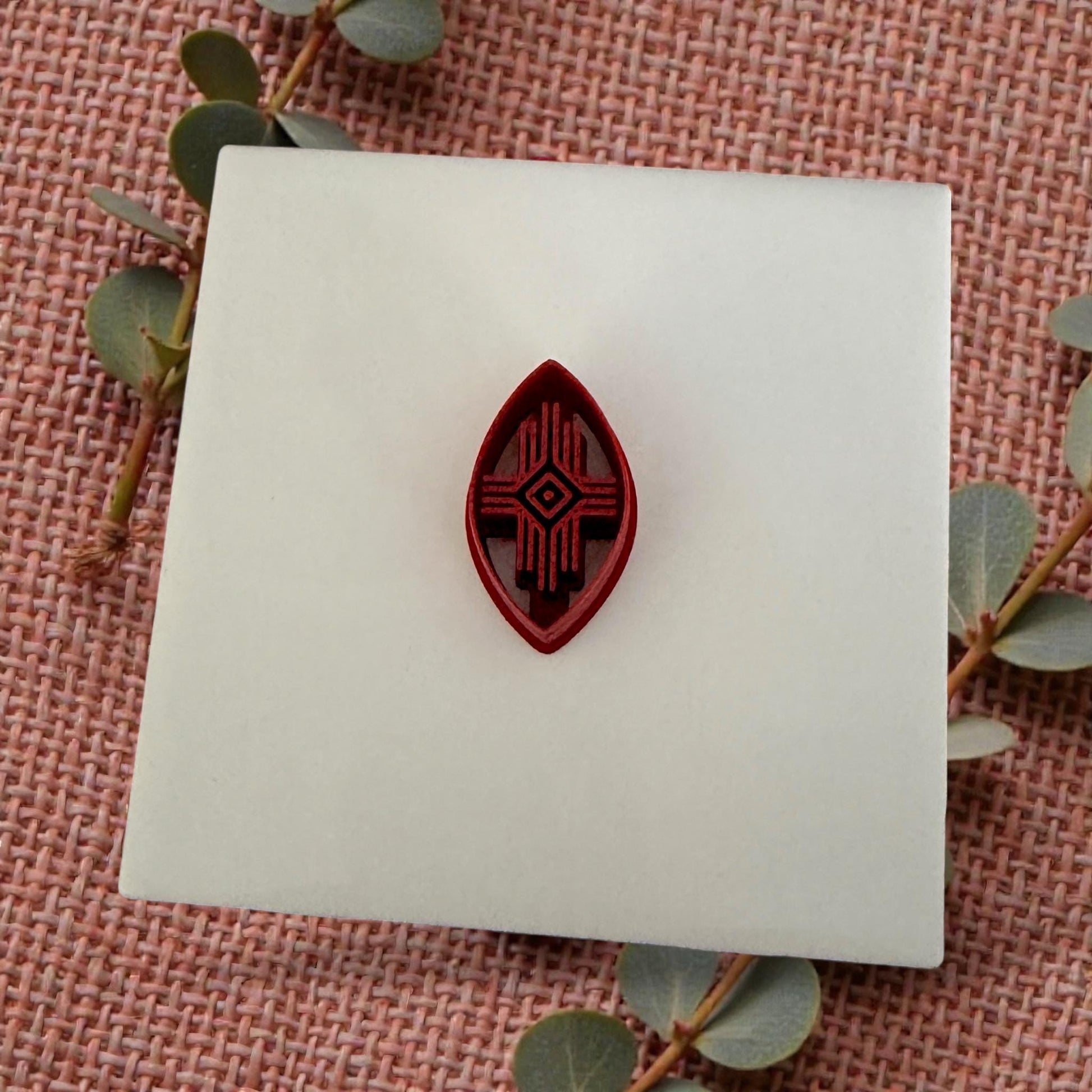 small oval tribal clay cutter displayed on white tile