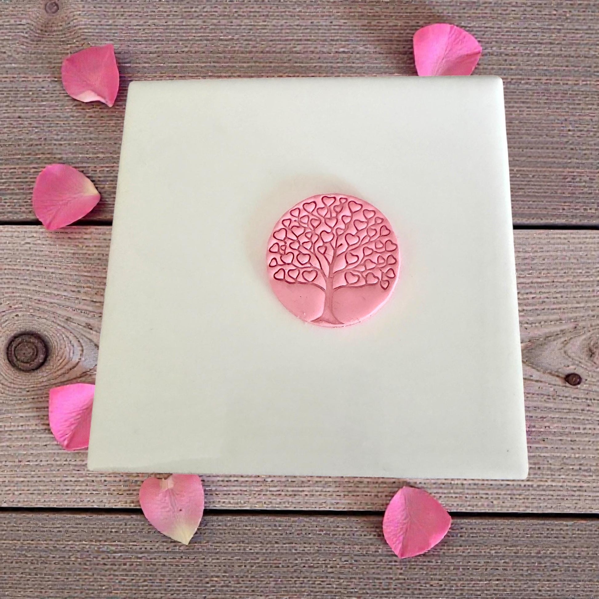 small pink heart tree impression on tile with petals