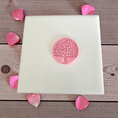 small pink heart tree impression on tile with petals