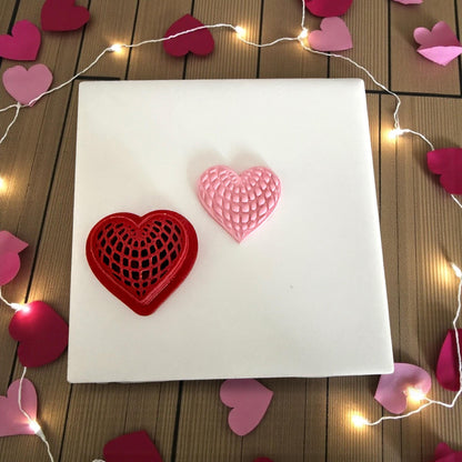 red heart web polymer clay cutter with pink clay imprint on white tile