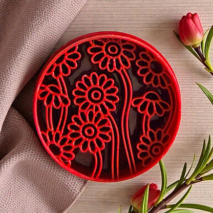 Red daisy floral clay cutter with curved stems and fabric backdrop
