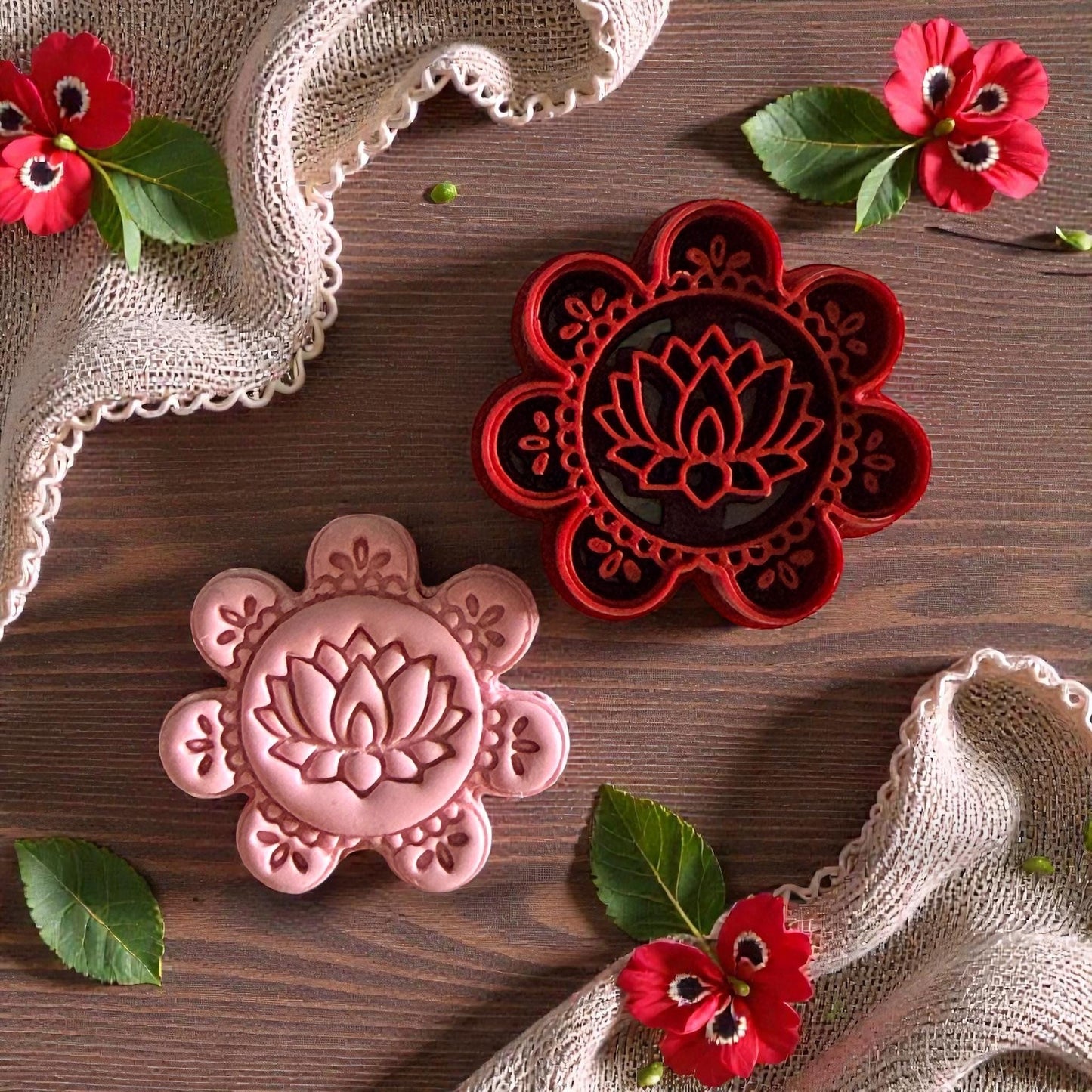 Pink and red lotus mandala clay impressions on wood surface with flowers