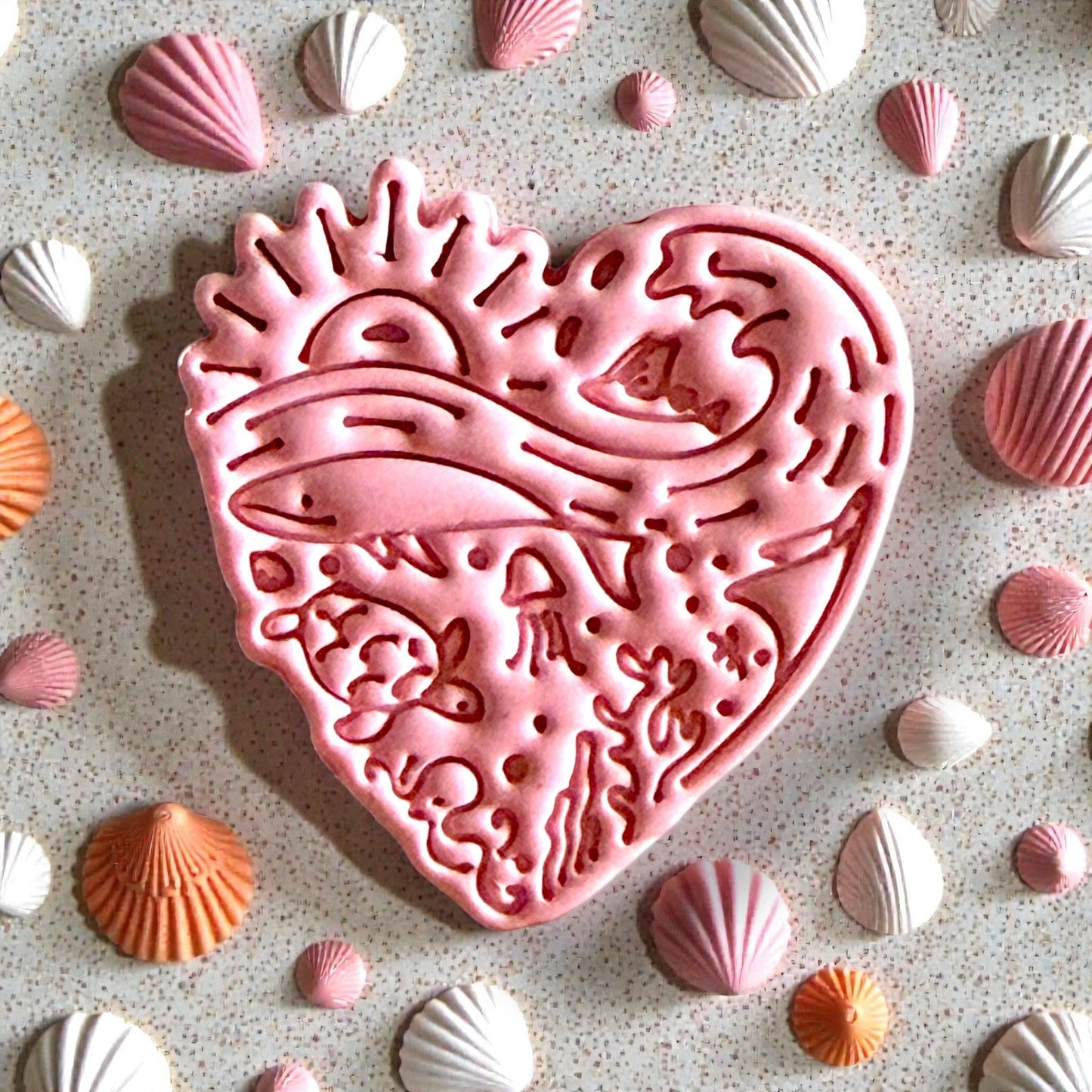 Pink heart clay design with sea creatures and sun pattern