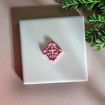pink cross clay impression on white tile