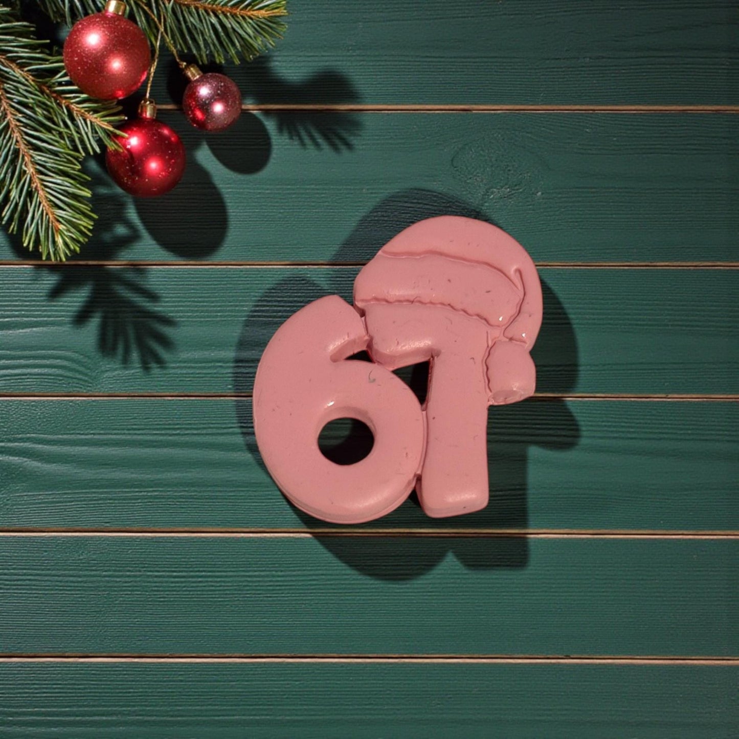 closeup of 67 santa hat clay piece on green wood background
