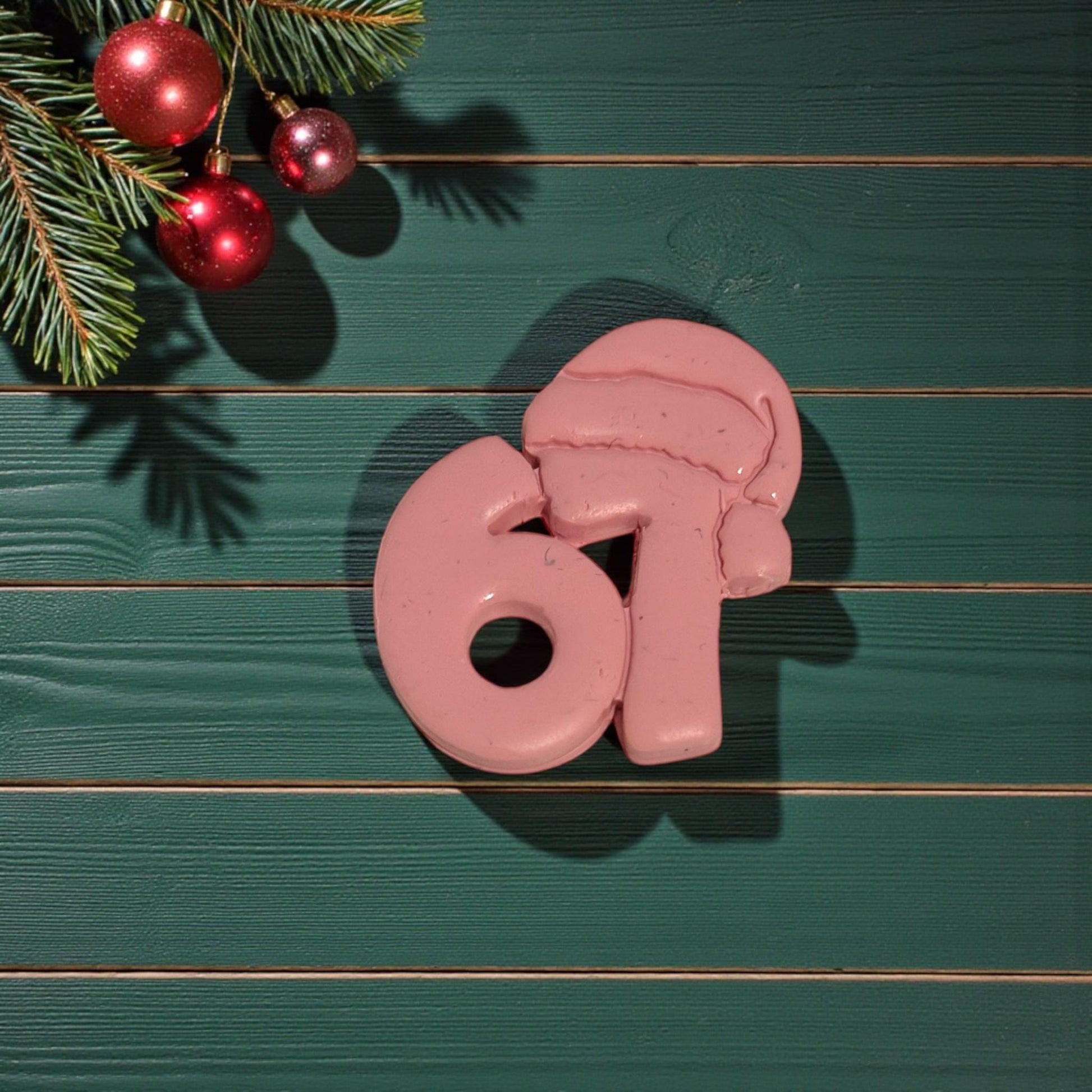 closeup of 67 santa hat clay piece on green wood background