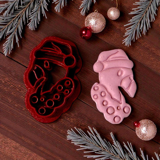 “Close-up of pink flamingo clay impression with winter greenery”