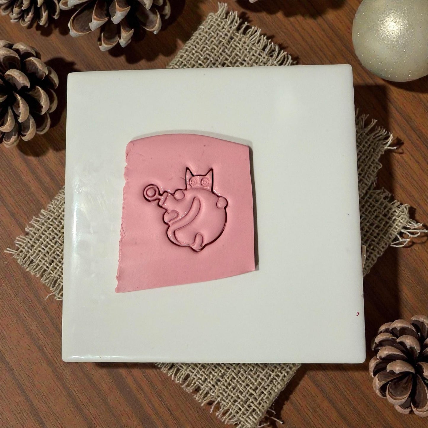 cat ornament impression pressed into pink clay sheet