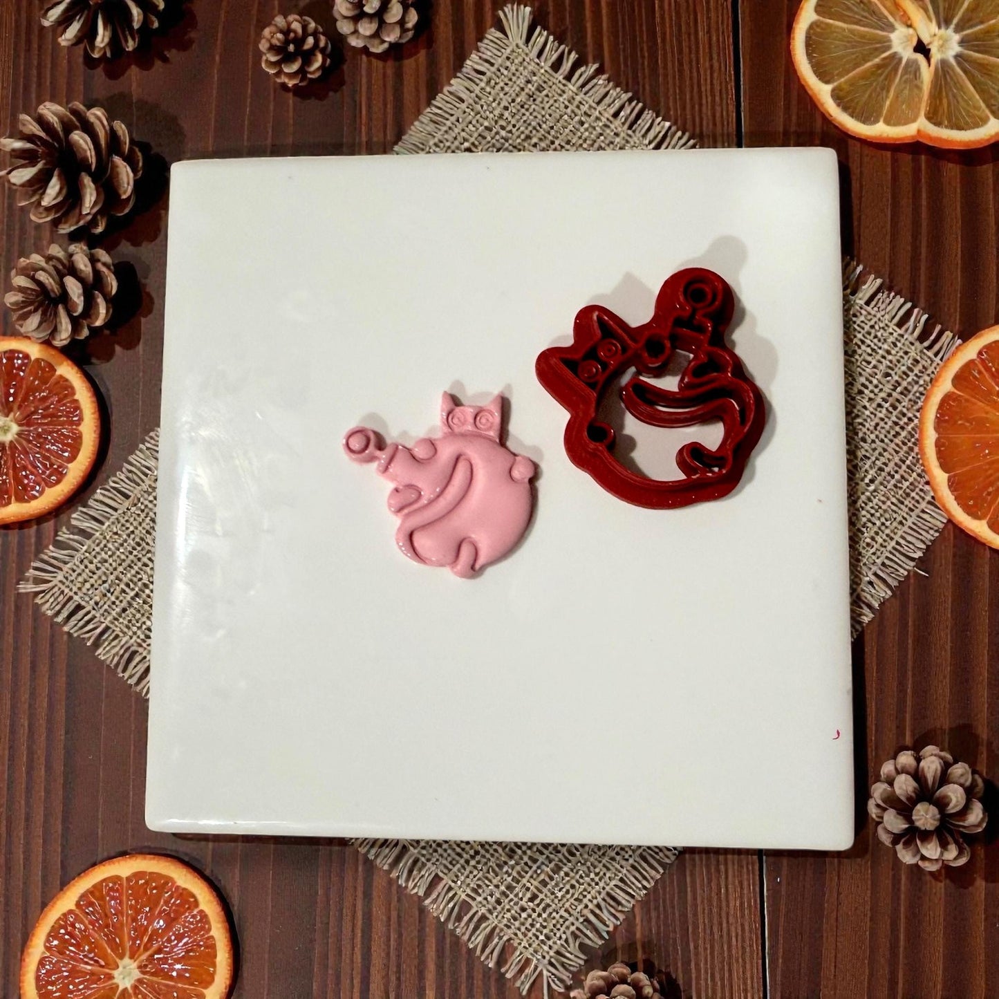cat ornament clay impression next to cutter on tile