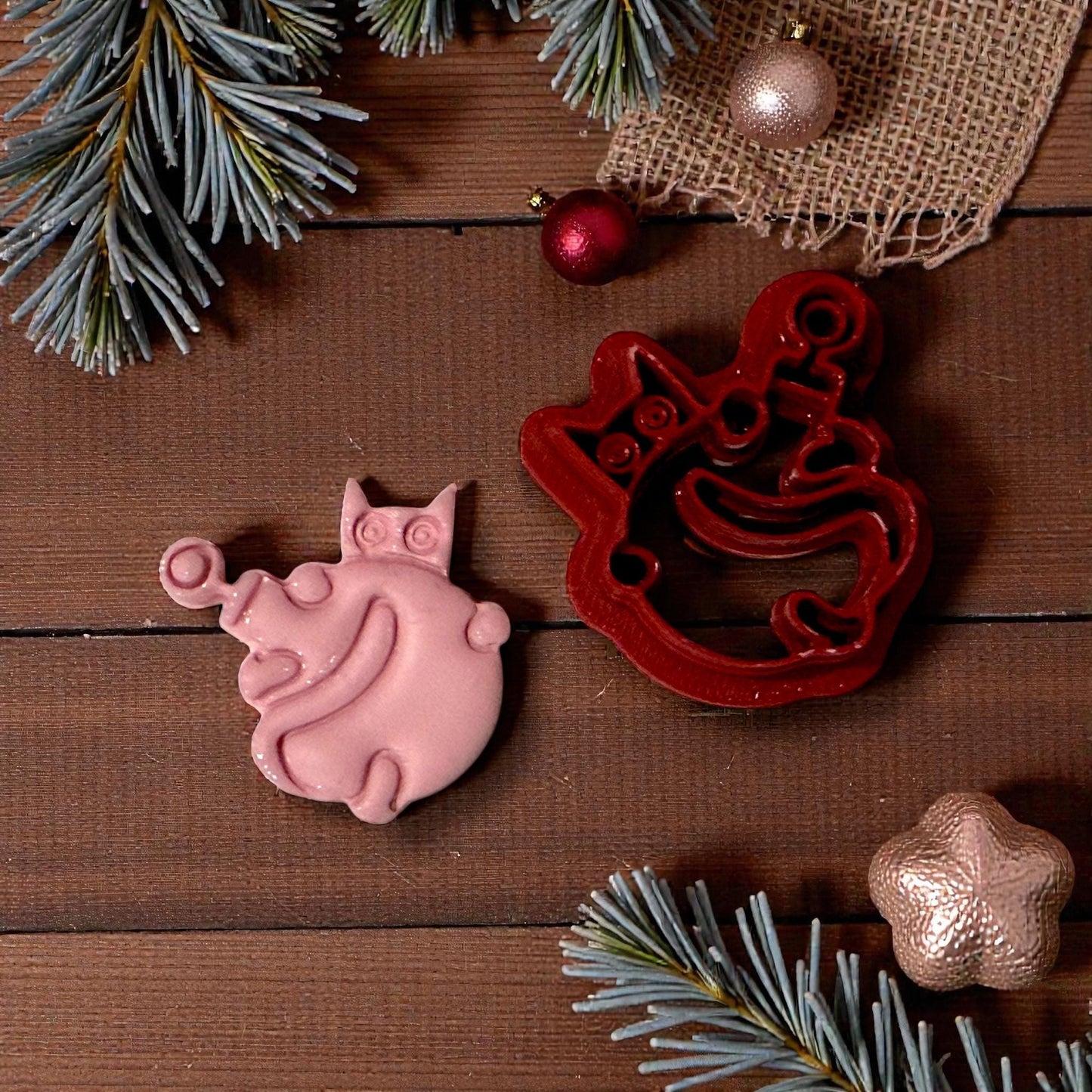 pink clay cat ornament impression with cutter on wood background