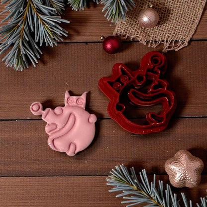 pink clay cat ornament impression with cutter on wood background