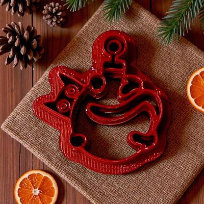 red polymer clay cutter shaped like a mischievous cat tangled in ornament