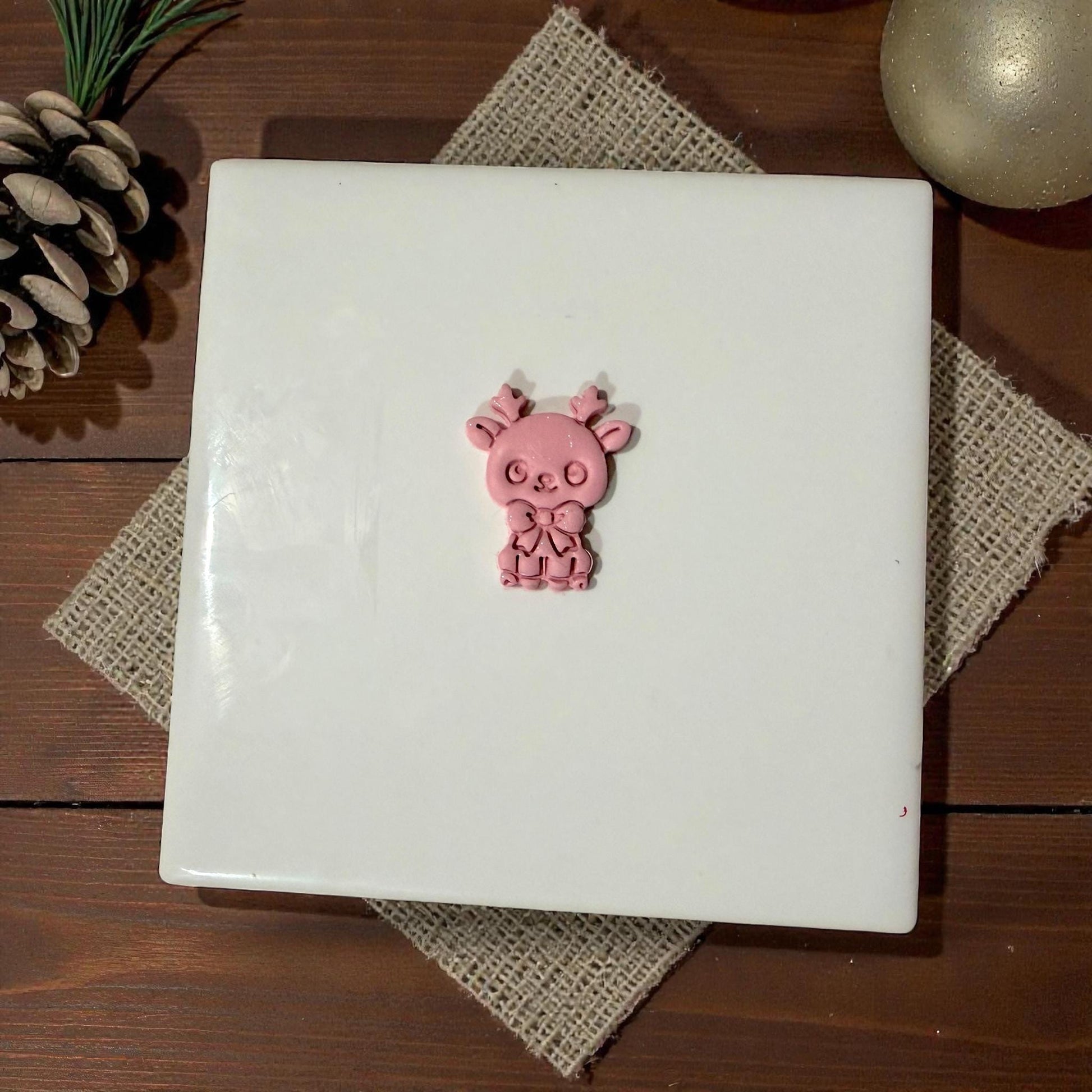 pink reindeer clay piece centered on tile