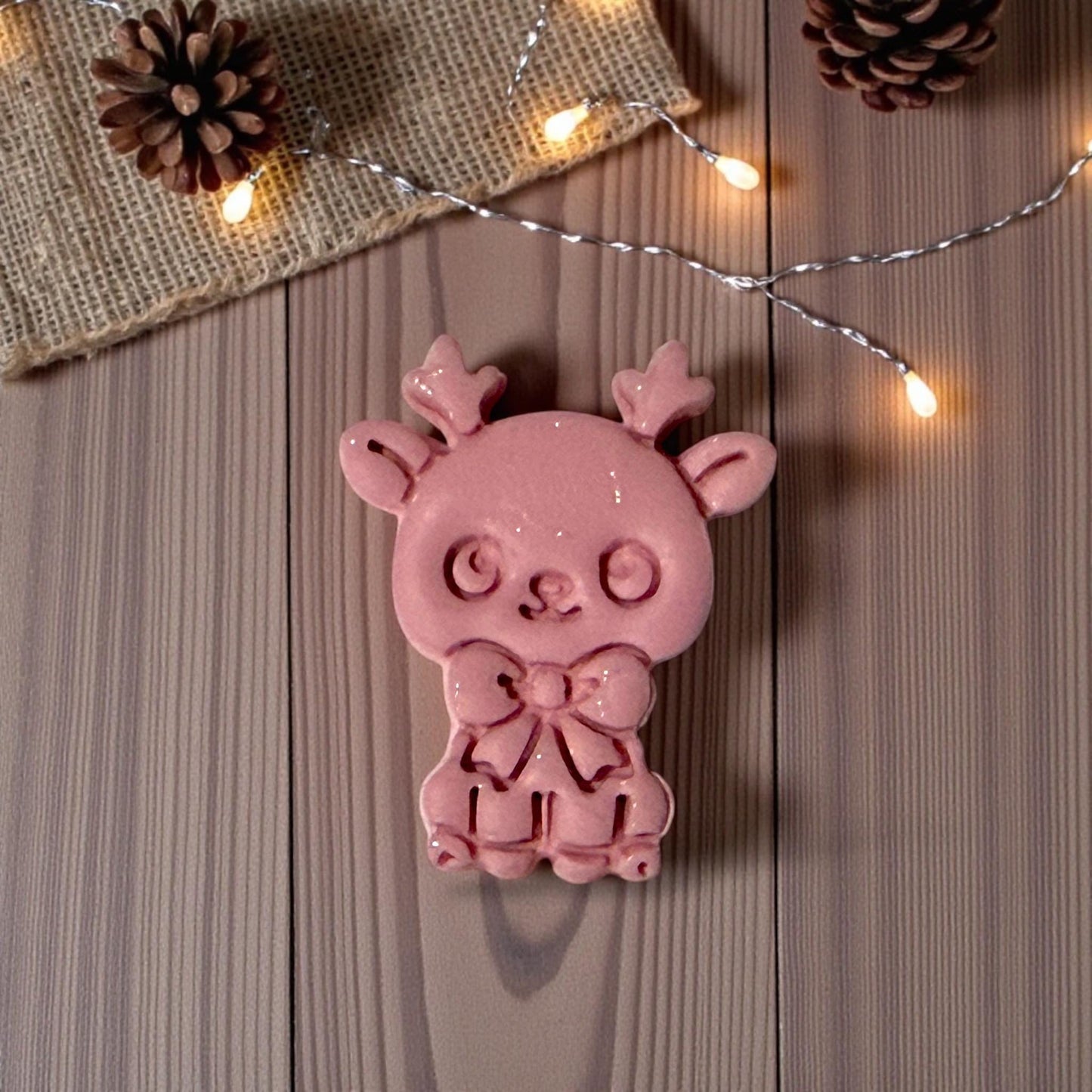 glossy pink reindeer clay piece on wood background