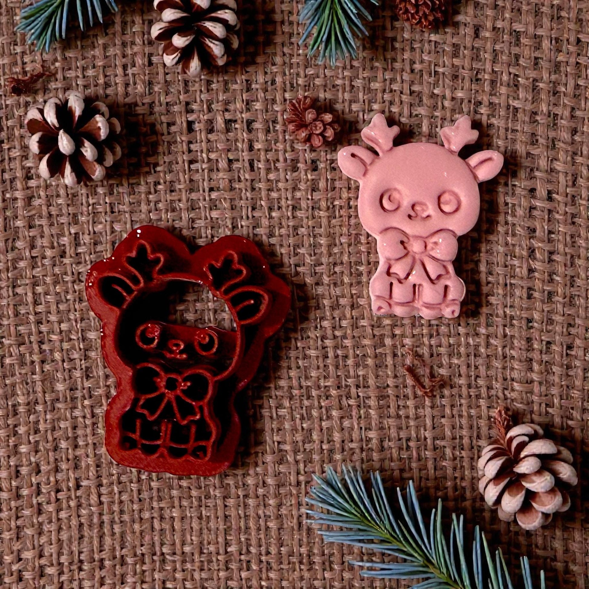 red reindeer cutter beside pink clay impression on burlap