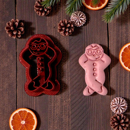 snowman clay cutter and pink clay impression on dark wood