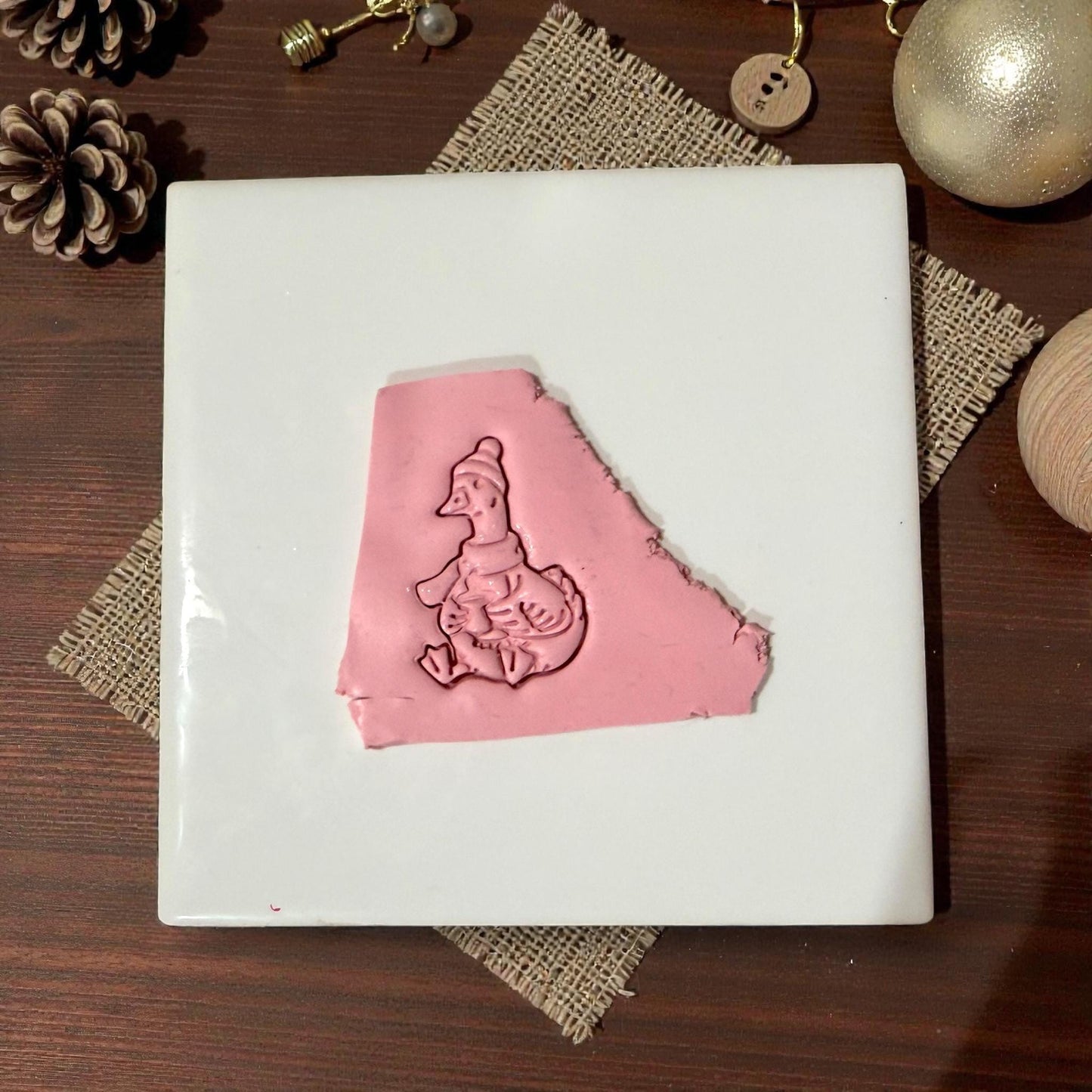 pink winter goose clay impression on white tile
