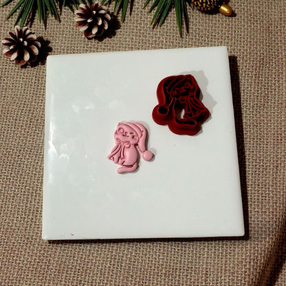 Cutter and clay kitty displayed with pinecones and greenery