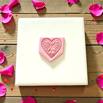 Boho heart clay impression on pink slab displayed on white tile