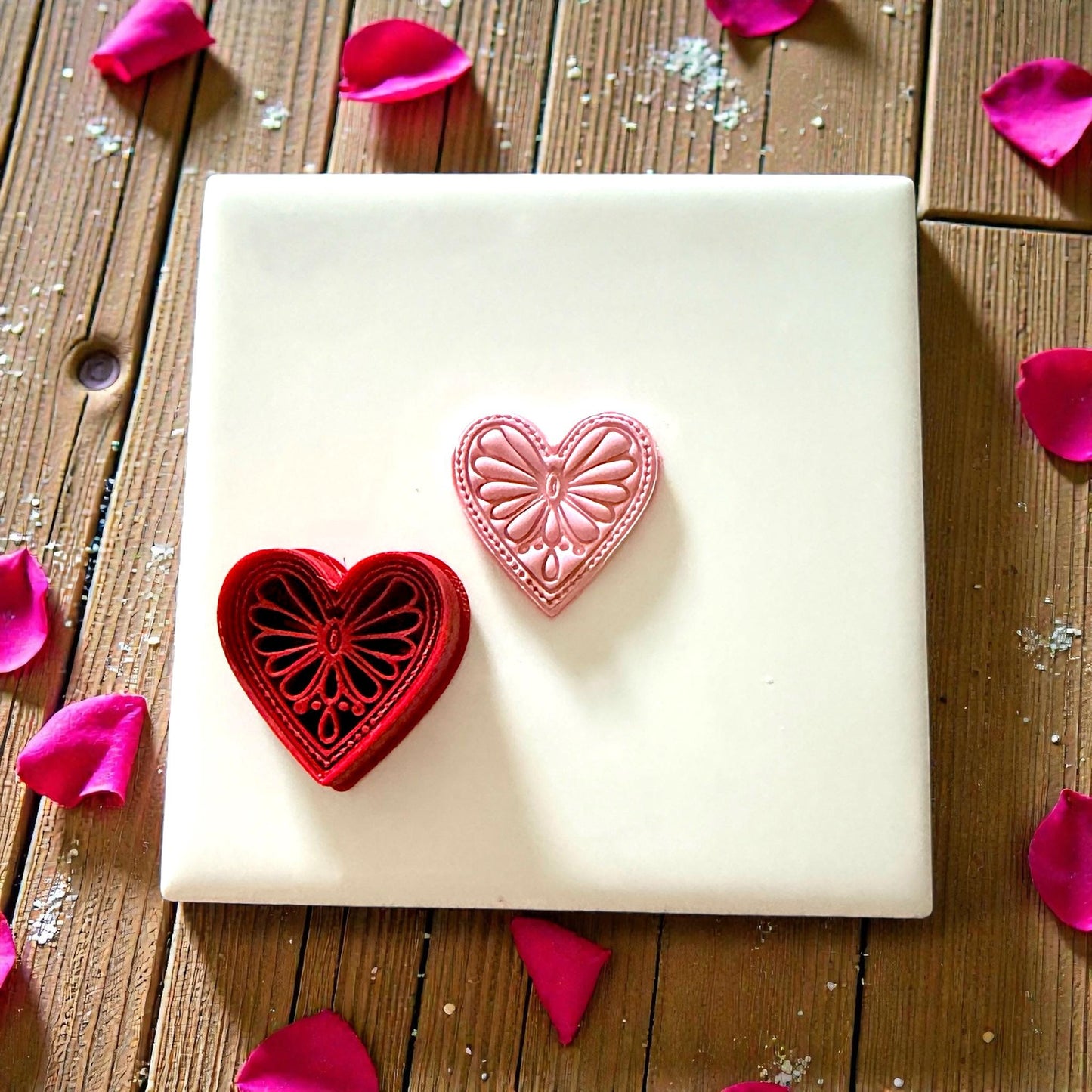 Boho heart cutter sitting on white tile with scattered petals