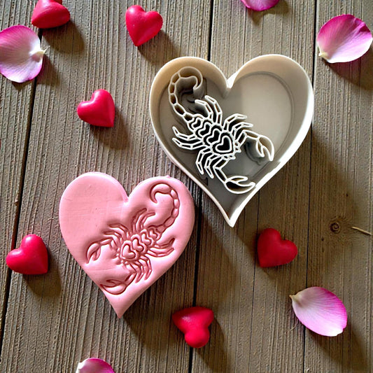pink heart scorpion clay piece beside cutter