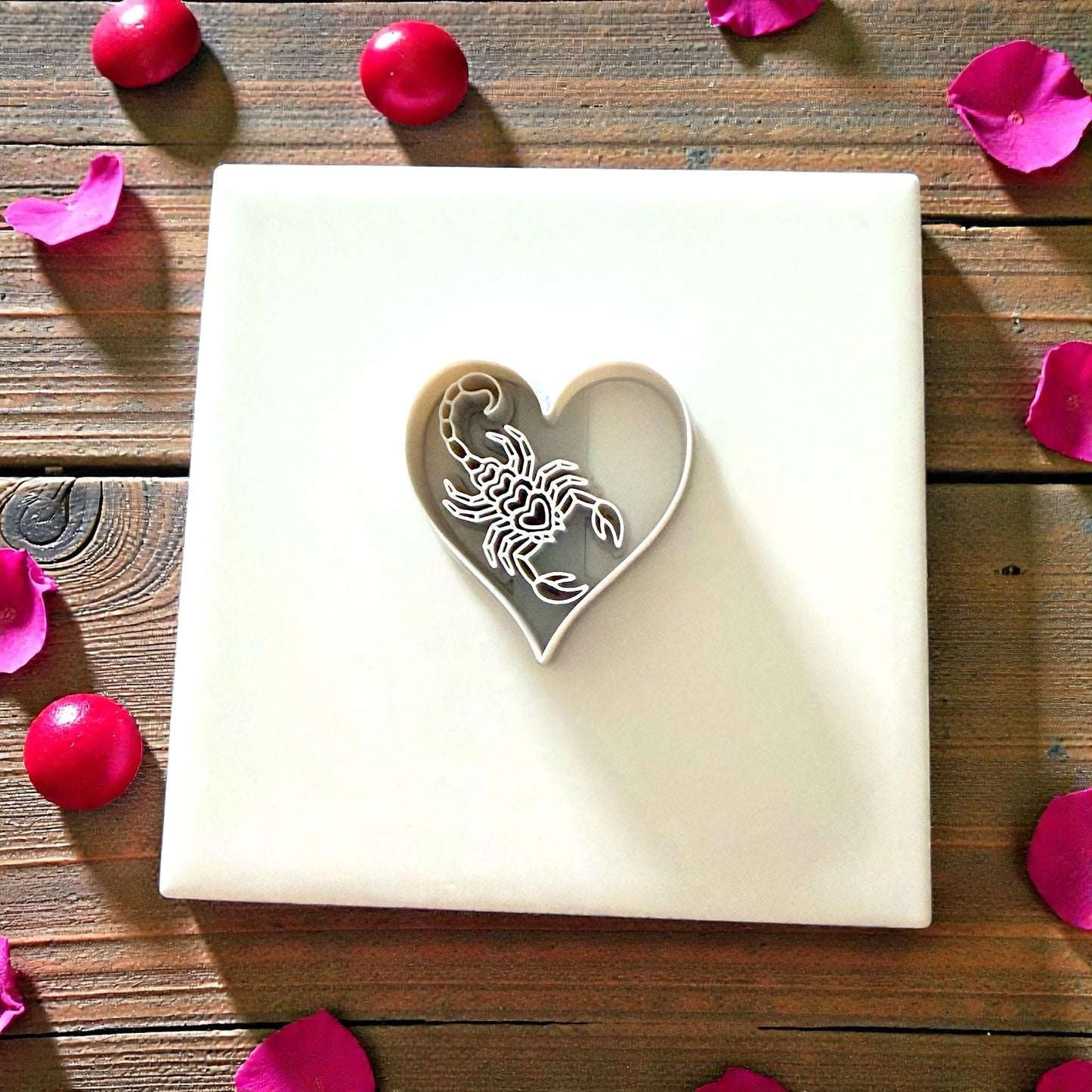 heart scorpion cutter centered on white tile