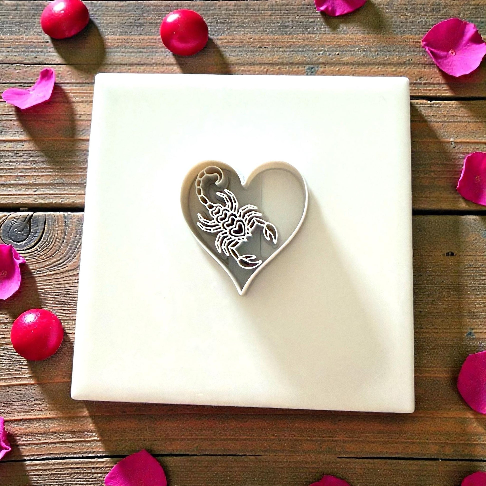 heart scorpion cutter centered on white tile