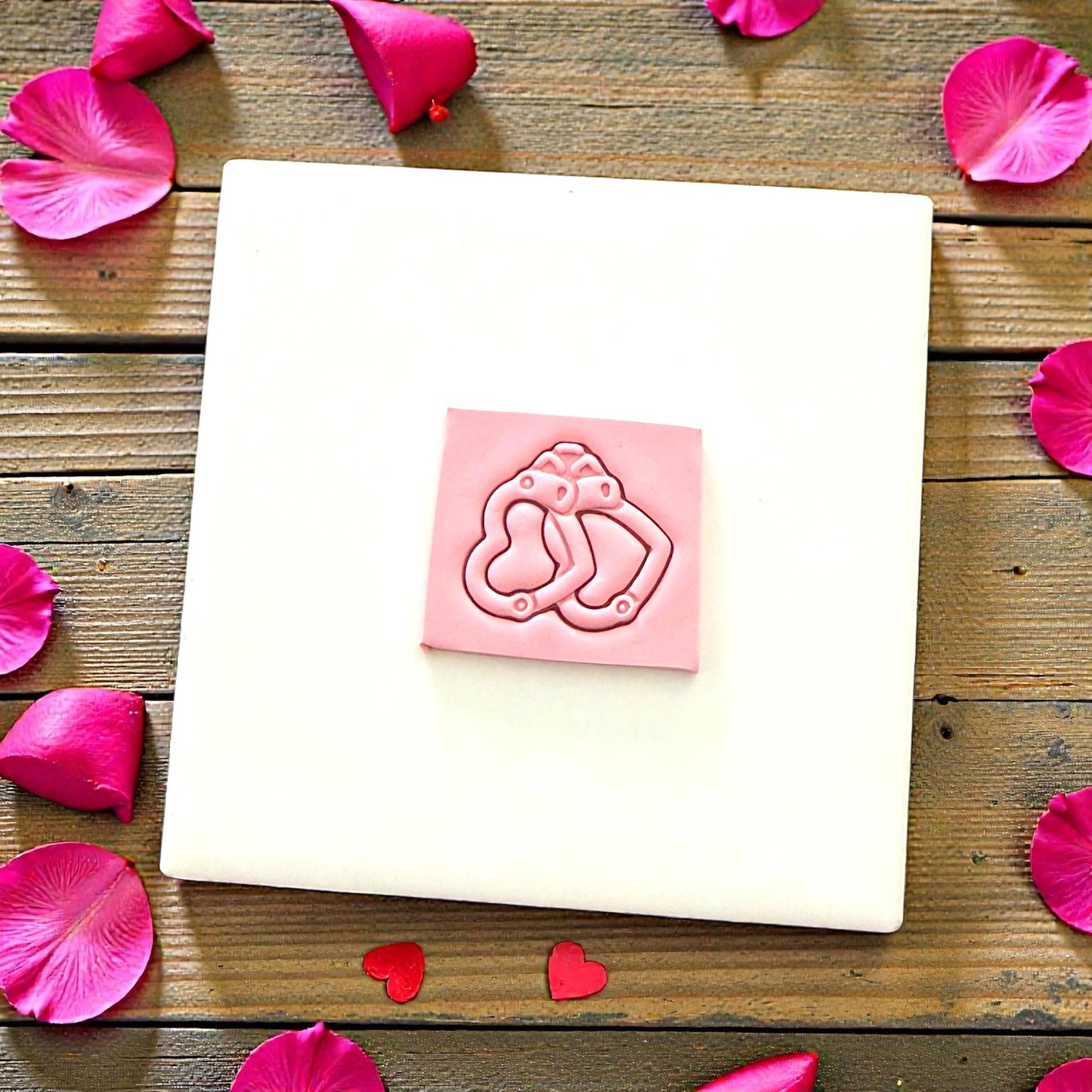 Heart handcuff clay imprint on pink slab