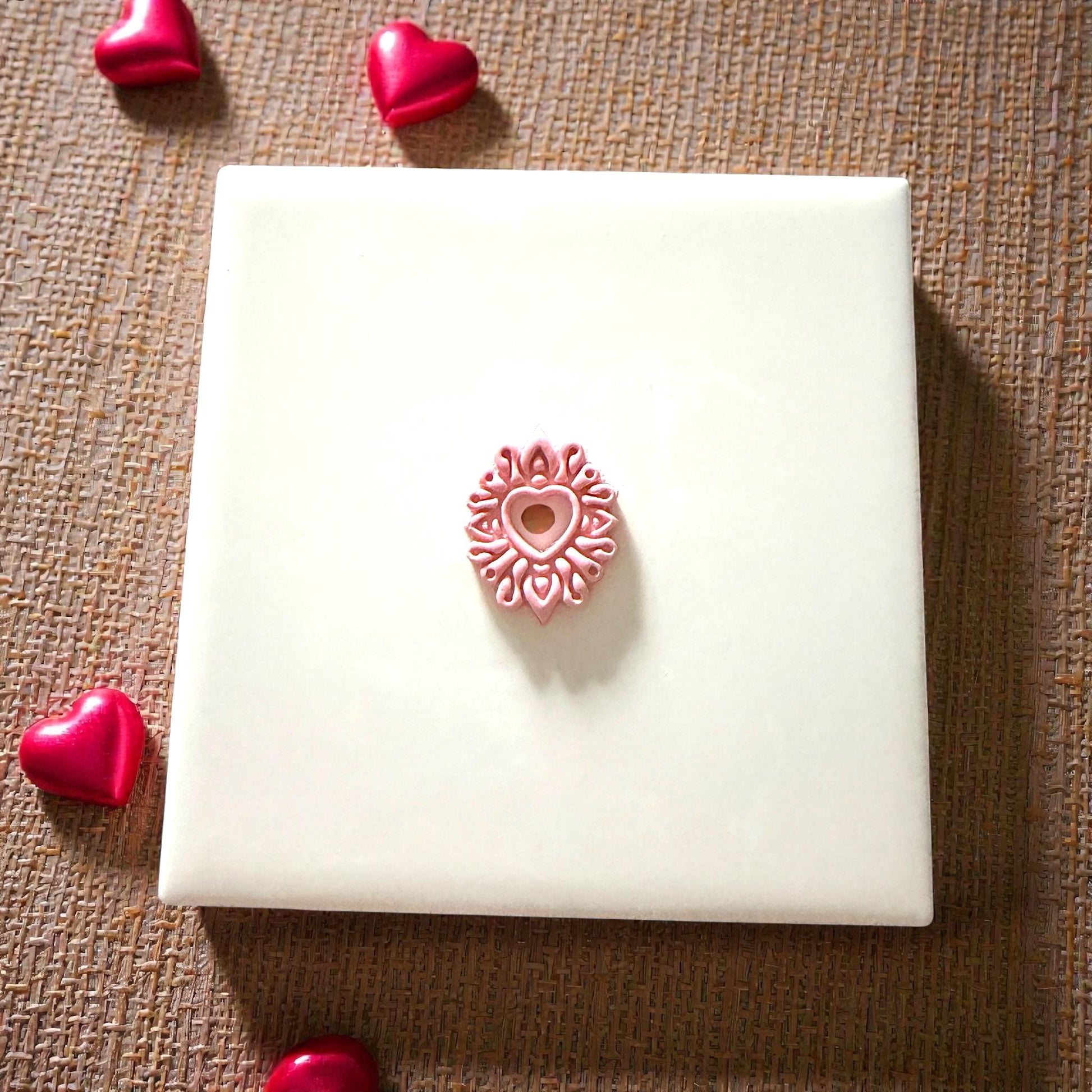heart mandala clay piece on tile with hearts