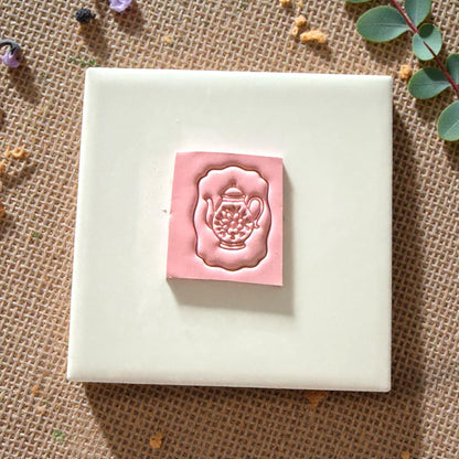 teapot clay cutter with floral center inside scalloped frame