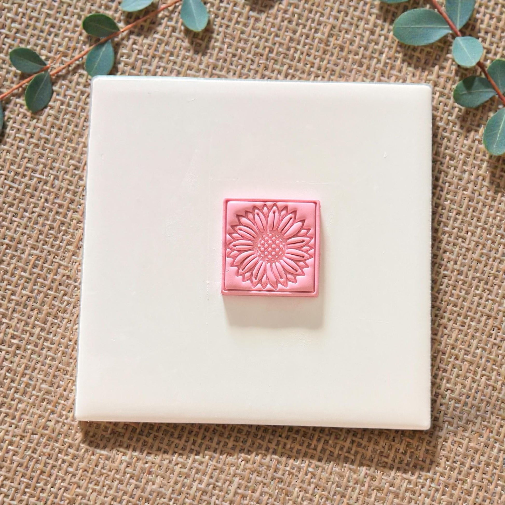sunflower clay impression centered on white tile