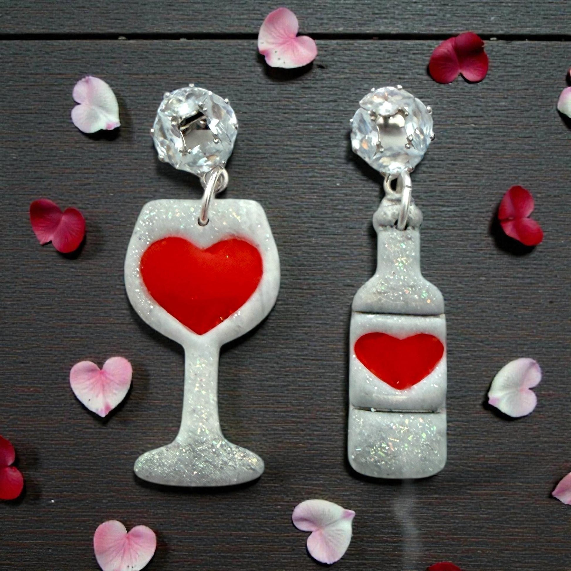 Finished clay wine glass and bottle earrings with red hearts on dark background