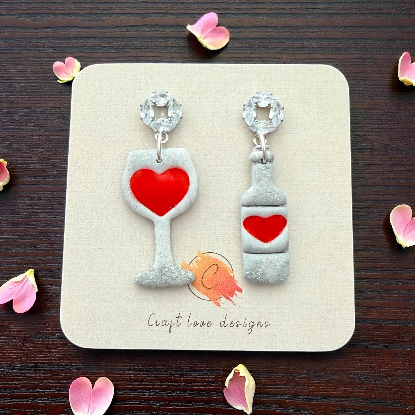 Sparkly heart wine glass and bottle earrings displayed on earring card