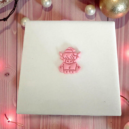 small highland cow clay piece on white tile with christmas decor
