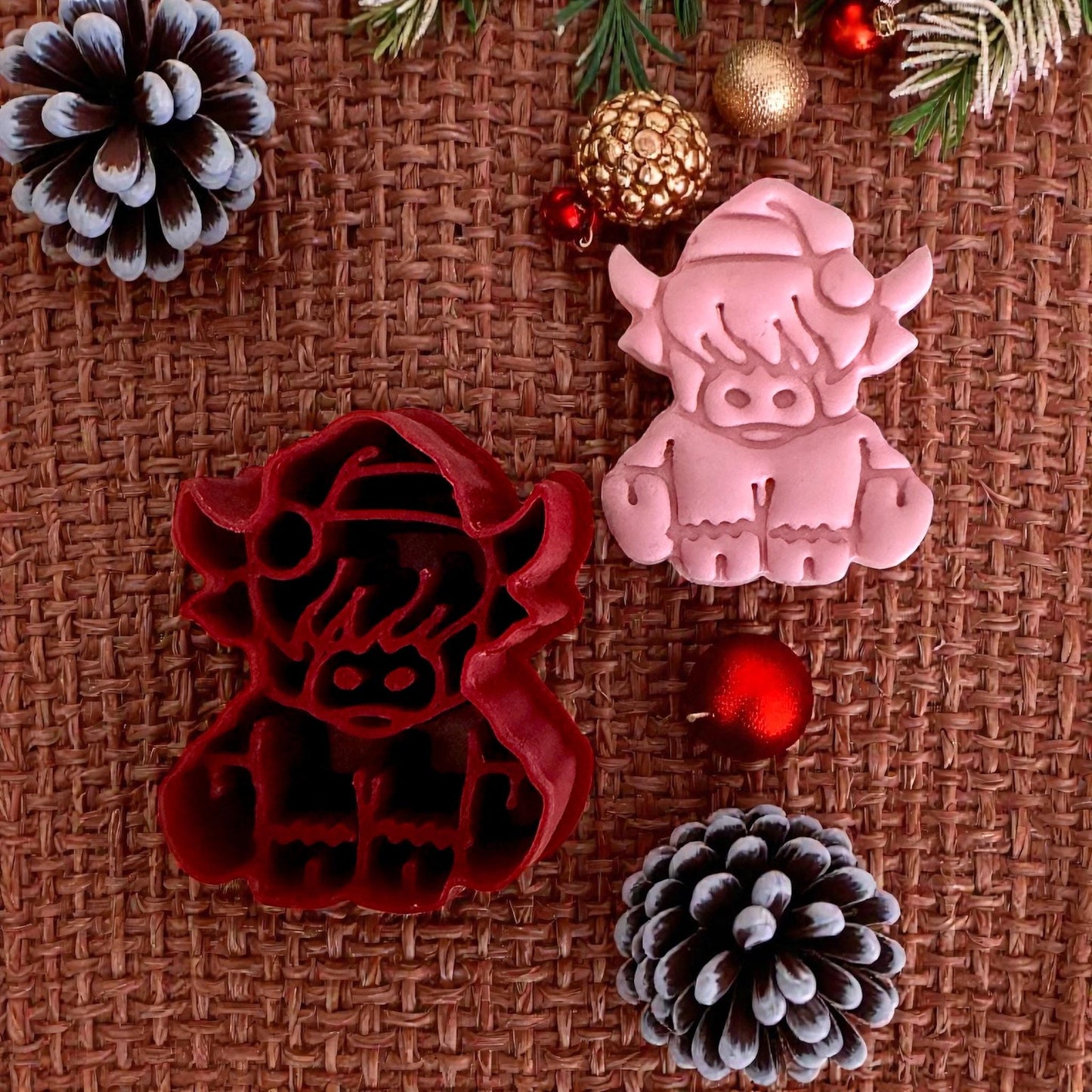 red highland cow cutter and pink clay impression with pinecones