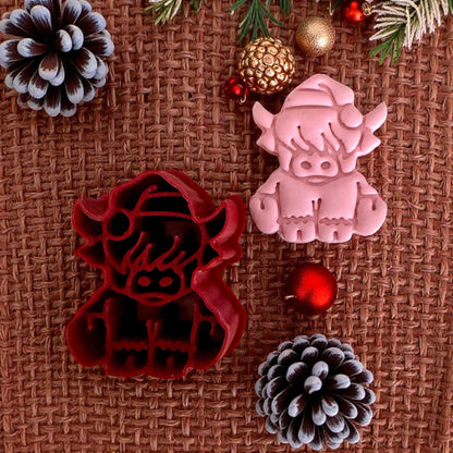red highland cow cutter and pink clay impression with pinecones