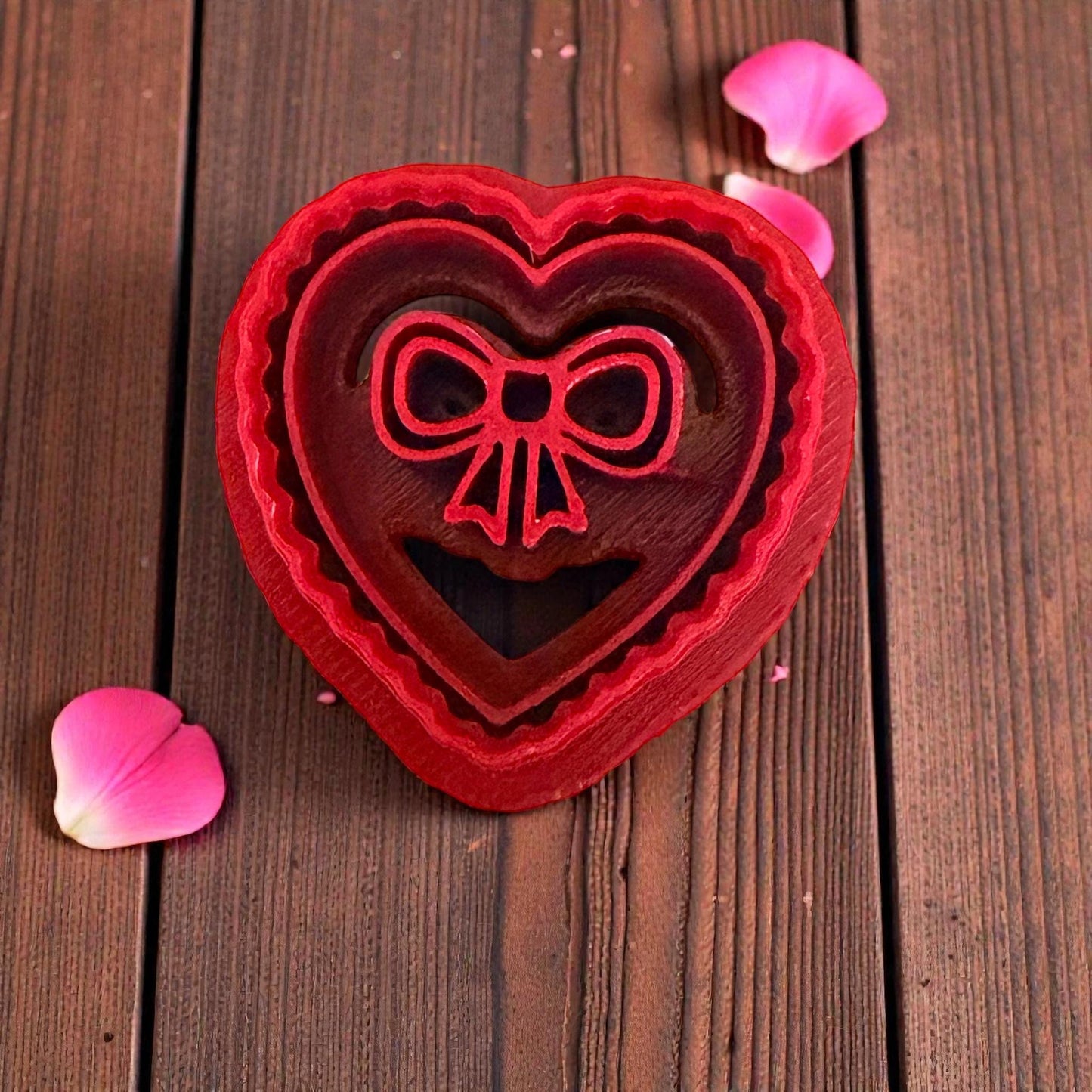Heart bow polymer clay cutter on wood background with petals