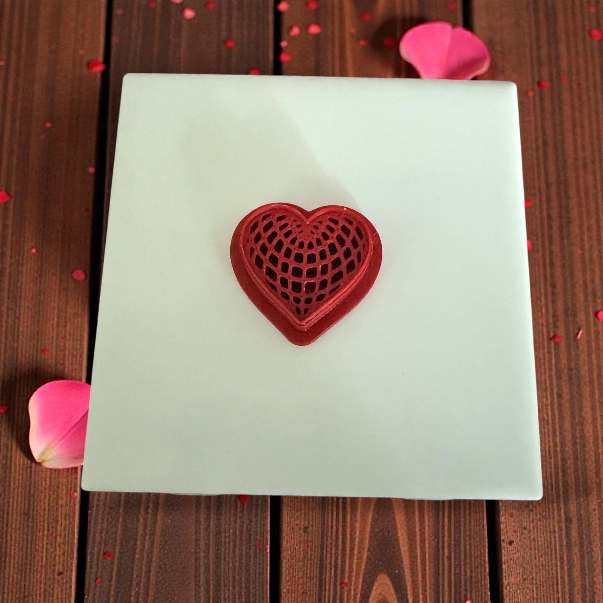 heart web cutter centered on white tile with pink petals