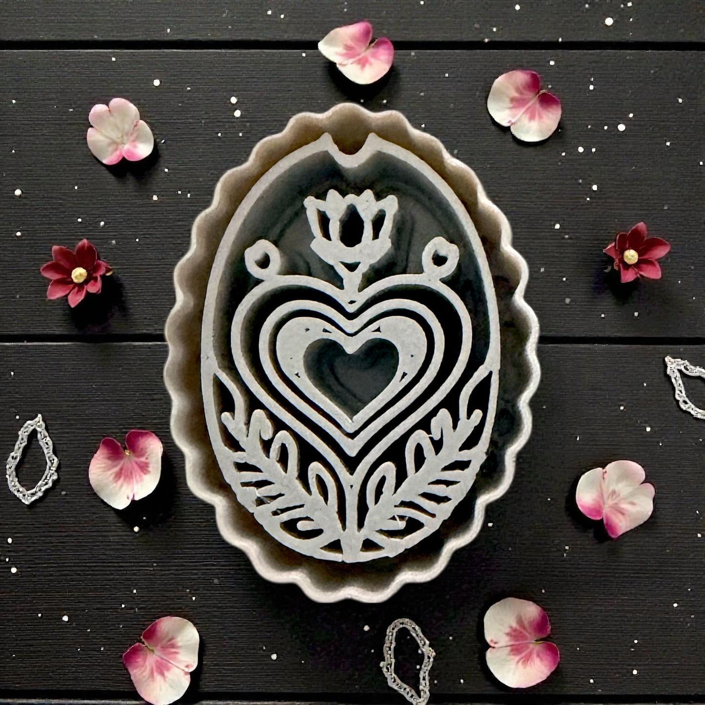 closeup of grey cutter next to pink clay folk design