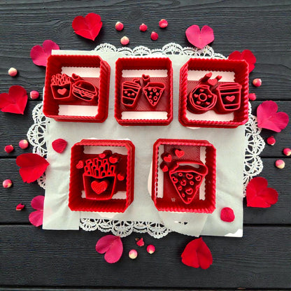 Five red square Valentine food polymer clay cutters with hearts on dark background