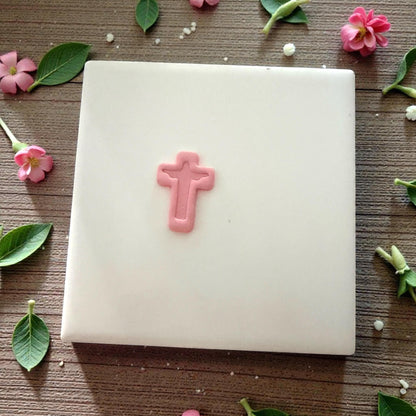 tiny pink clay cross on tile