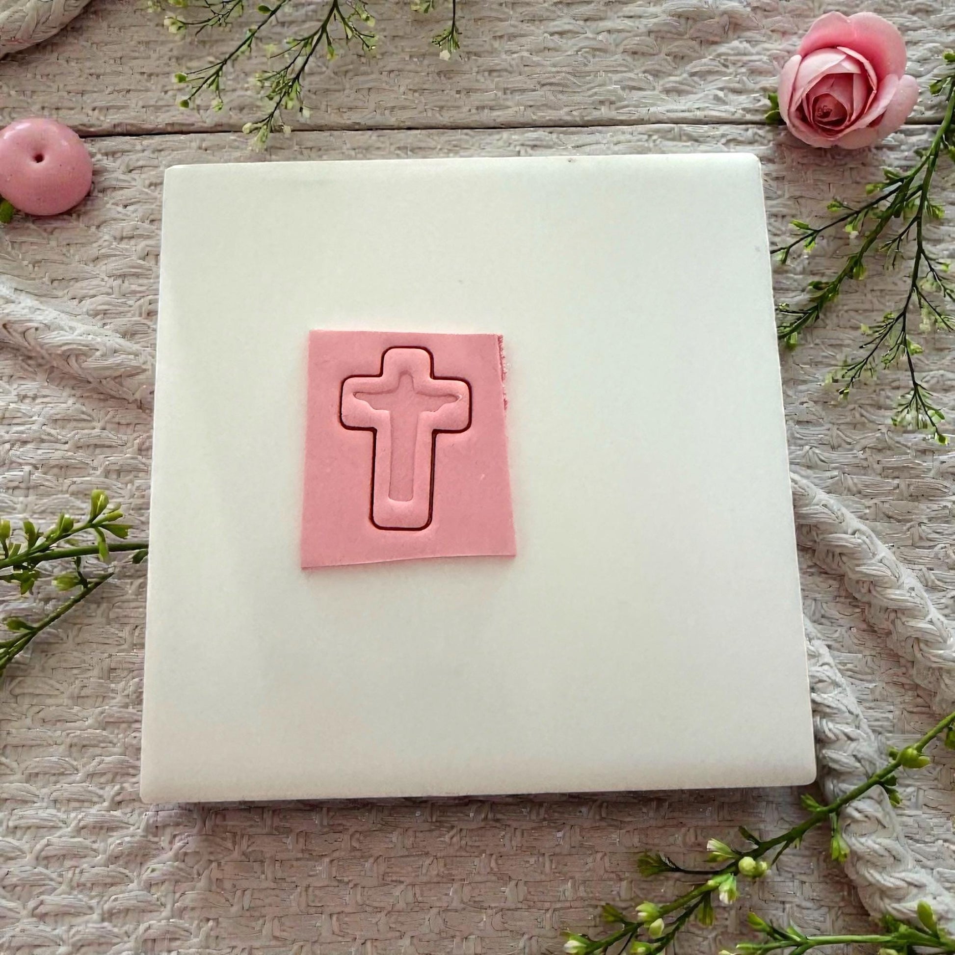 pink clay cross imprint on tile