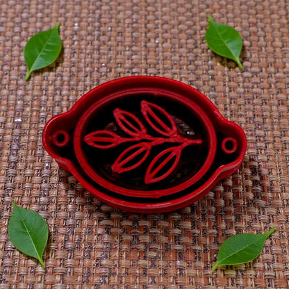 red oval leaf bracelet cutter on woven mat