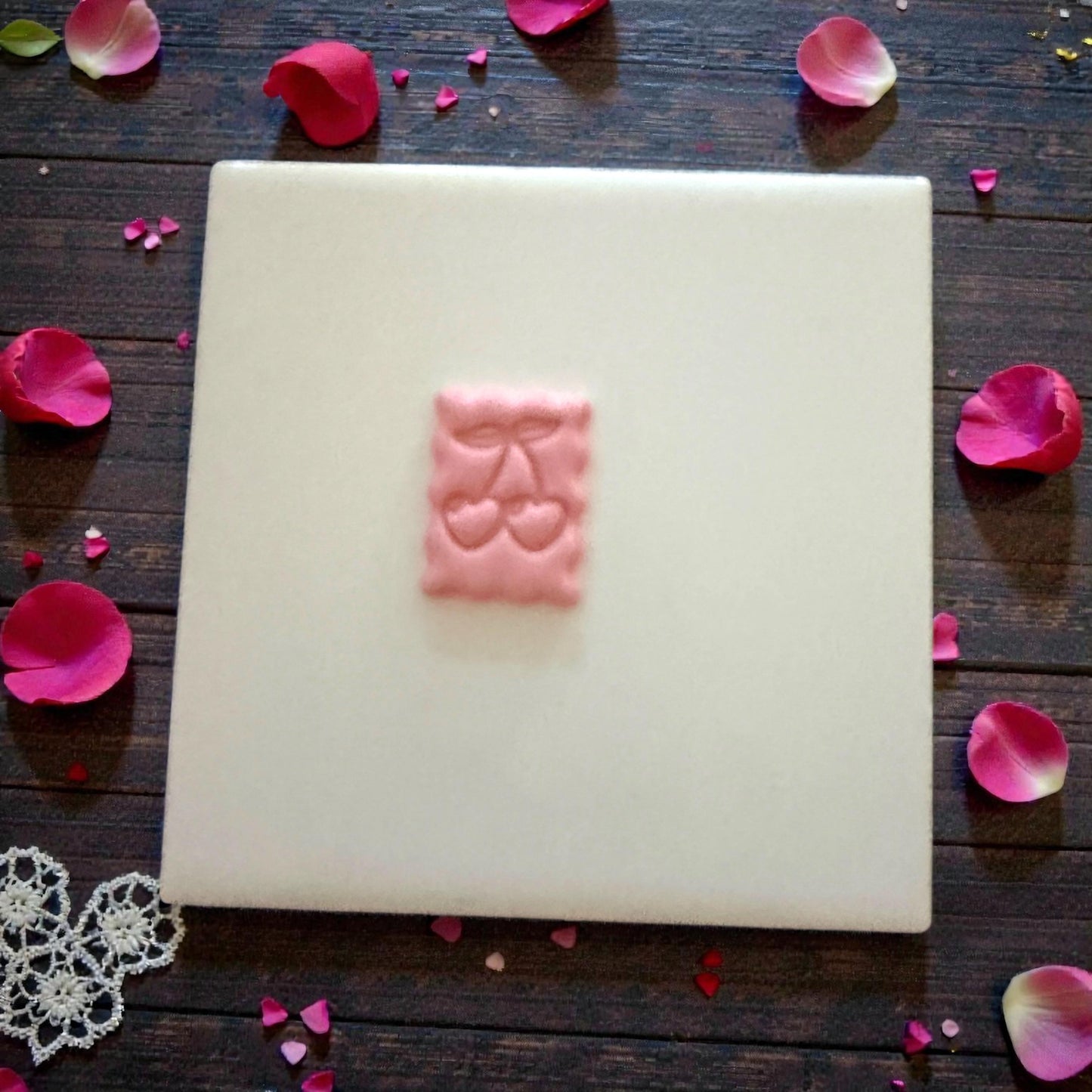 small cherry clay stamp centered on white tile