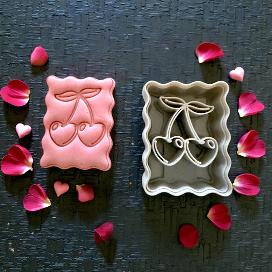 cherry clay impression and cutter flatlay with petals