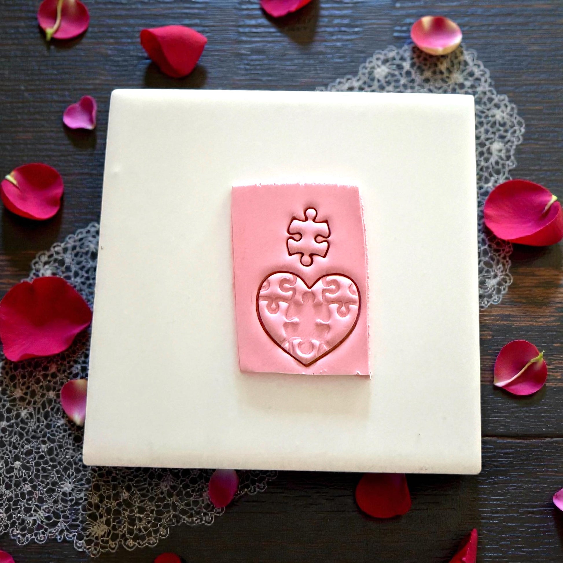 puzzle heart clay impression on white tile
