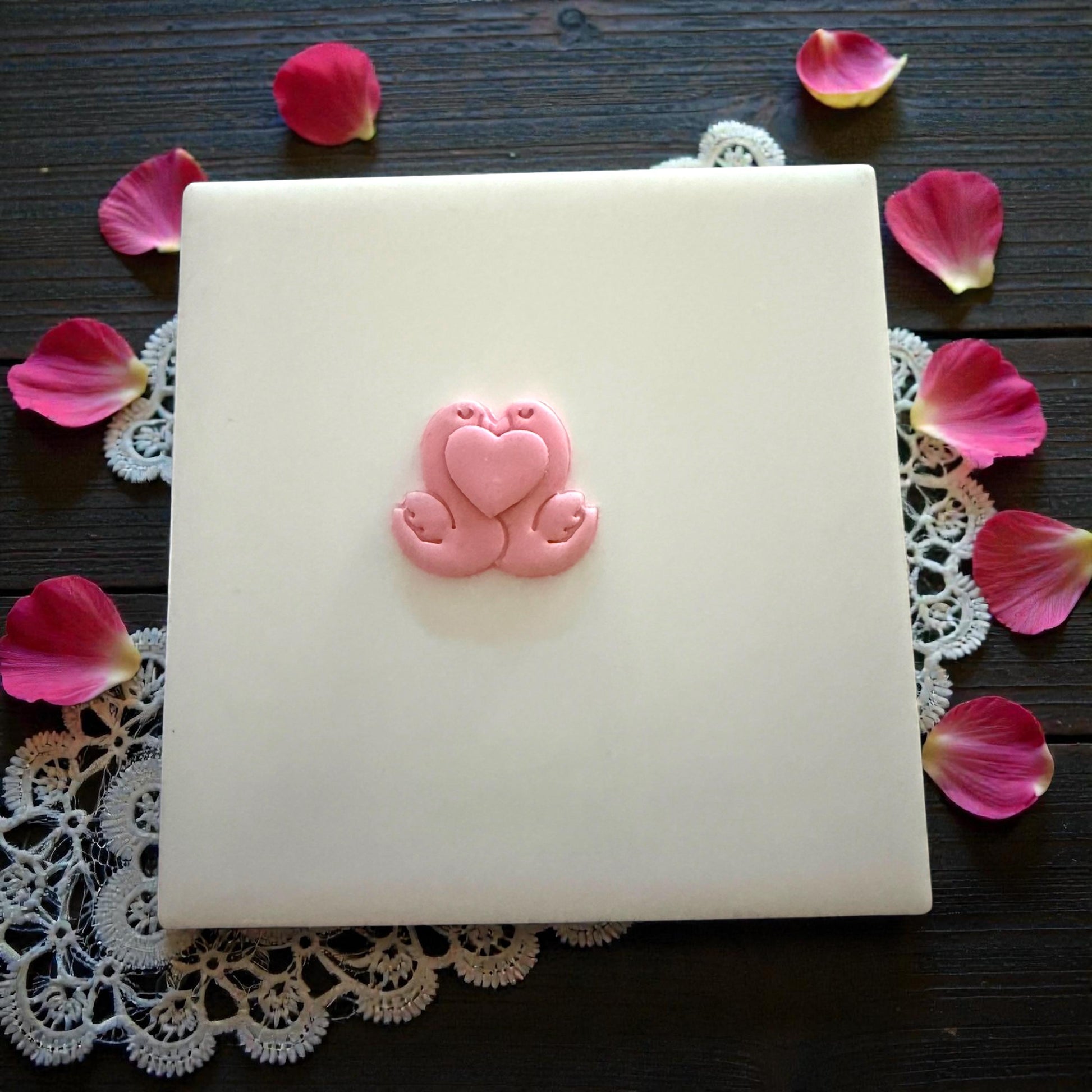 swan couple clay shape on white tile with petals