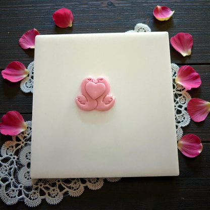 swan couple clay shape on white tile with petals
